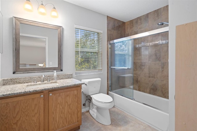 full bathroom featuring tile patterned flooring, toilet, combined bath / shower with glass door, and vanity