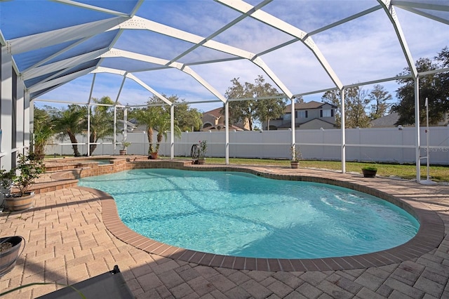 view of swimming pool featuring an in ground hot tub, a patio, and glass enclosure