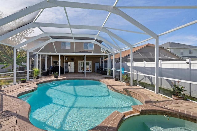 view of pool with a lanai, a patio area, and an in ground hot tub