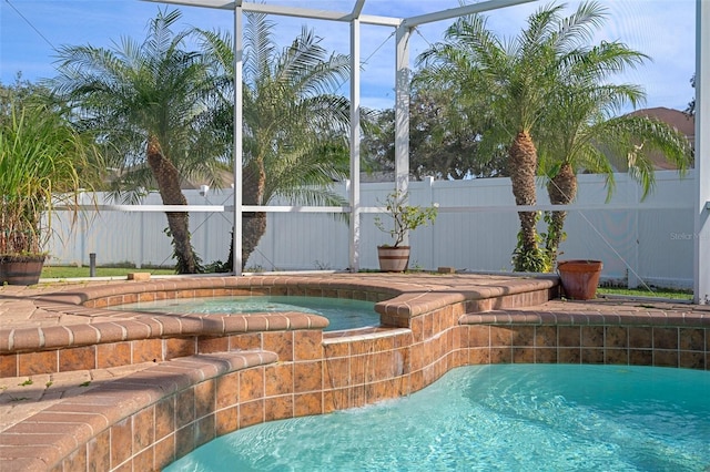 view of swimming pool featuring glass enclosure and an in ground hot tub