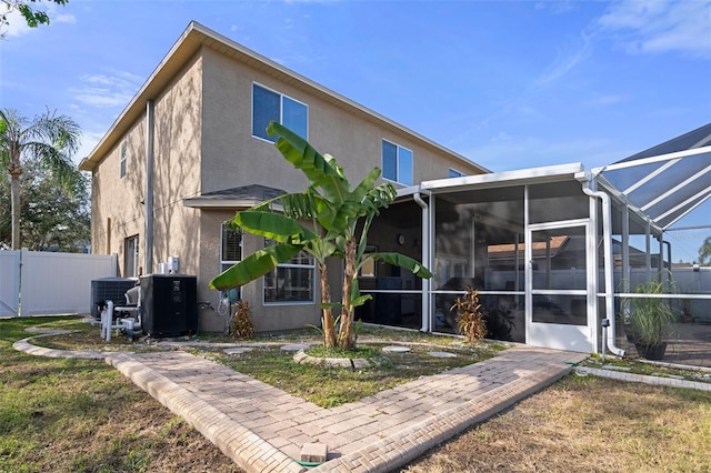 back of property featuring glass enclosure and central air condition unit