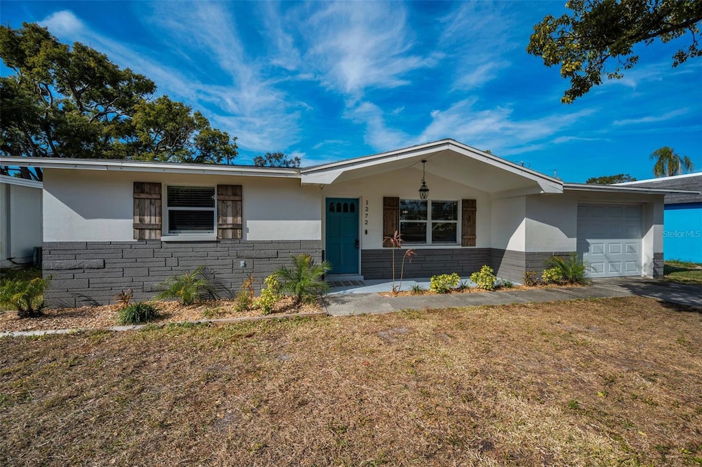 ranch-style home with a garage and a front lawn