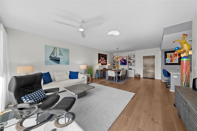 living room featuring hardwood / wood-style floors and ceiling fan with notable chandelier