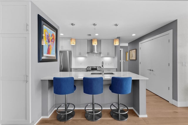 kitchen featuring a kitchen breakfast bar, sink, pendant lighting, and appliances with stainless steel finishes