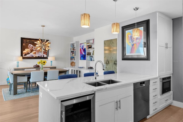 kitchen with sink, wine cooler, light stone counters, light hardwood / wood-style floors, and white cabinets