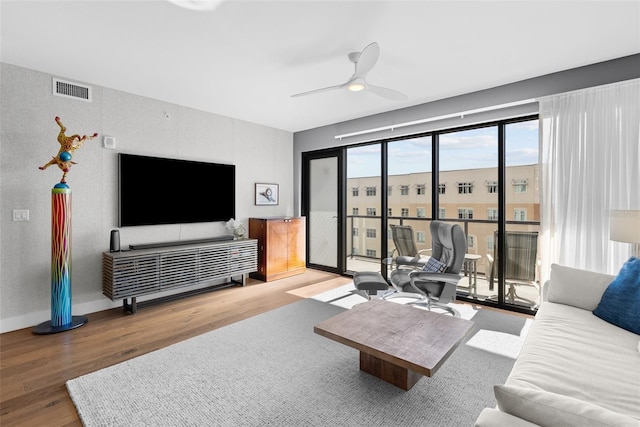 living room featuring ceiling fan and hardwood / wood-style flooring