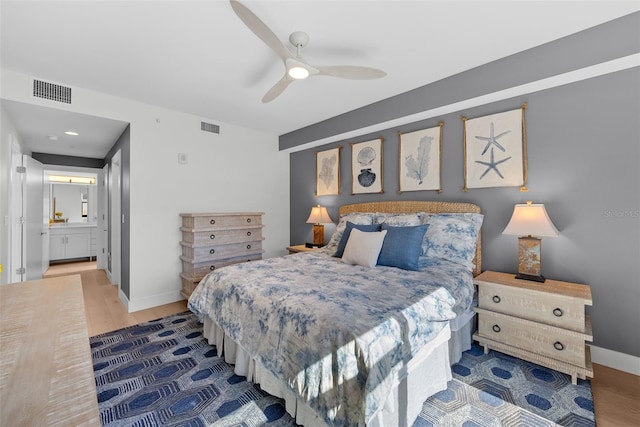 bedroom featuring ceiling fan, wood-type flooring, and ensuite bath