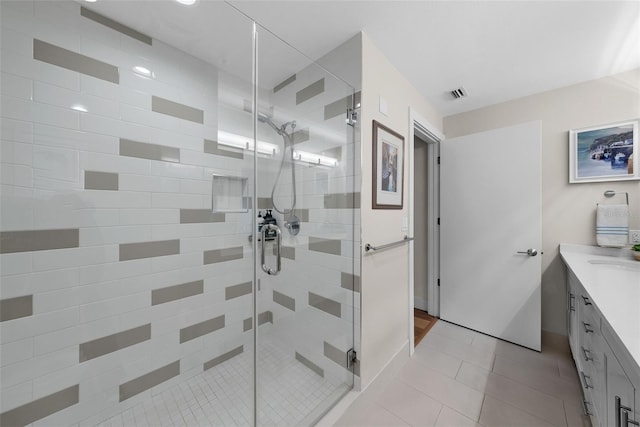 bathroom featuring tile patterned floors, a shower with door, and vanity