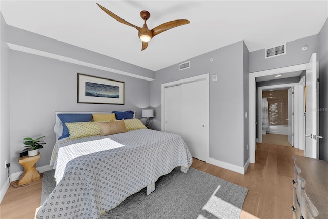 bedroom with a closet, light hardwood / wood-style flooring, and ceiling fan