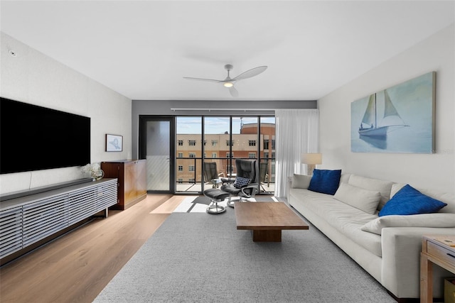 living room featuring ceiling fan and light wood-type flooring