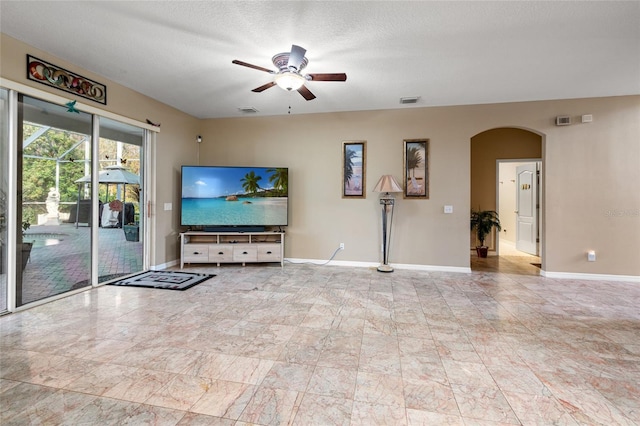 living room with ceiling fan and a textured ceiling