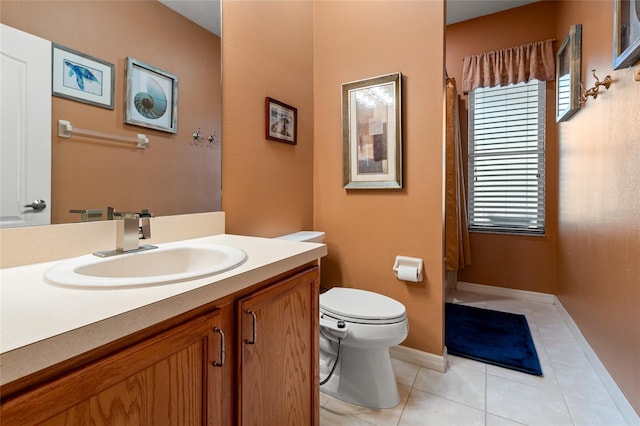 bathroom with tile patterned flooring, vanity, and toilet