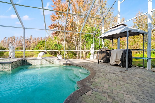 view of swimming pool featuring a lanai, a grill, a jacuzzi, pool water feature, and a patio