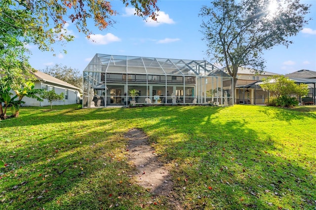 rear view of property featuring a lanai and a lawn