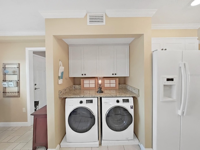 washroom with light tile patterned flooring, washing machine and dryer, and ornamental molding