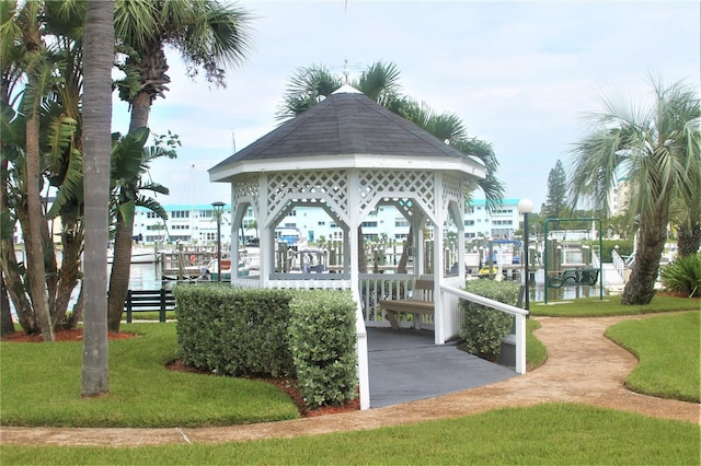 surrounding community featuring a lawn, a boat dock, a gazebo, and a water view