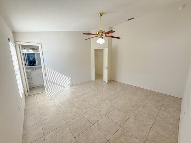 tiled spare room featuring ceiling fan, a healthy amount of sunlight, and lofted ceiling