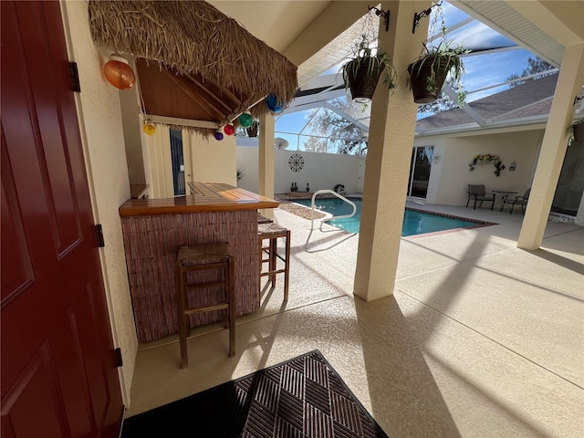 view of pool featuring a lanai, a patio area, and exterior bar