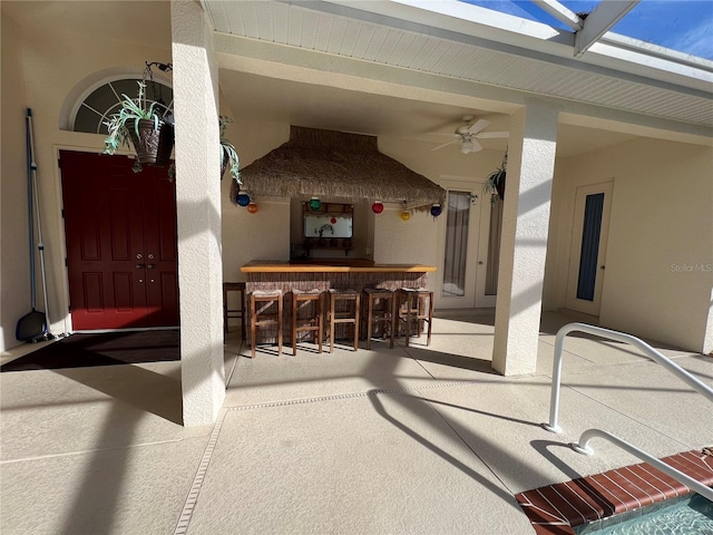 view of patio / terrace featuring exterior bar and ceiling fan