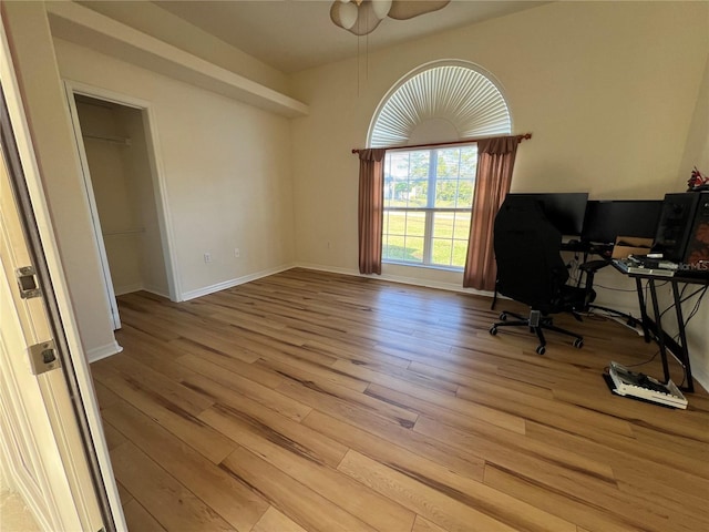 unfurnished office with light hardwood / wood-style floors and ceiling fan