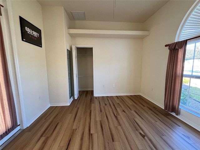 unfurnished bedroom with wood-type flooring and a closet