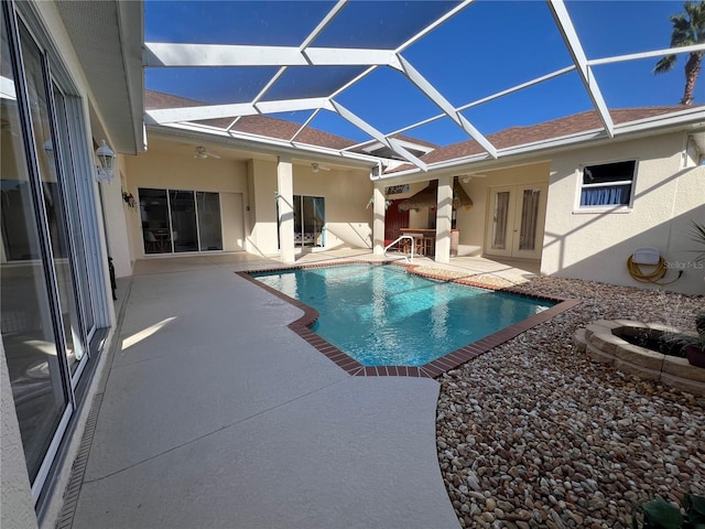 view of pool with a patio area, ceiling fan, french doors, and glass enclosure