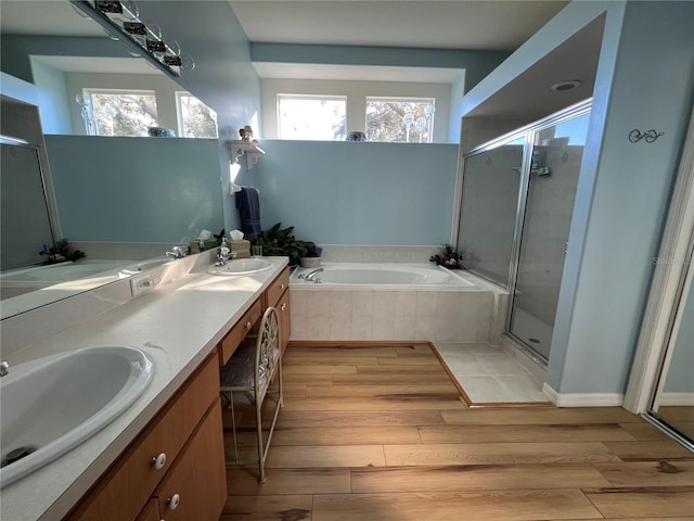 bathroom featuring hardwood / wood-style flooring, vanity, and separate shower and tub