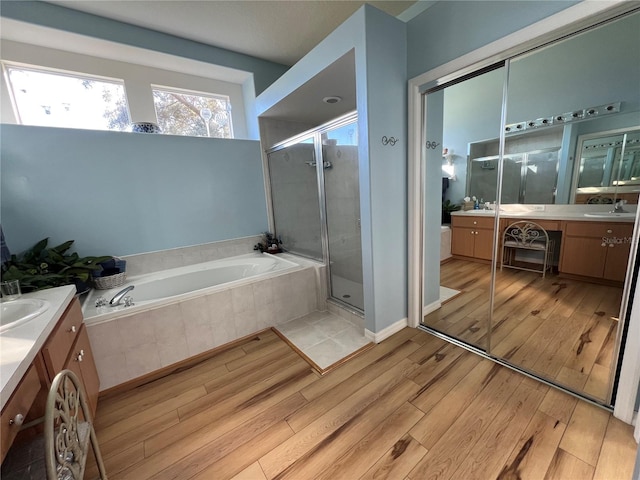 bathroom featuring vanity, shower with separate bathtub, and hardwood / wood-style flooring