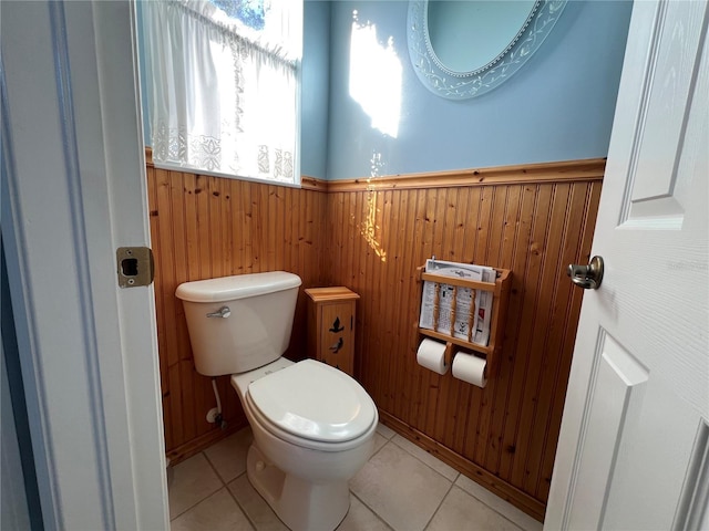 bathroom with tile patterned floors and wooden walls