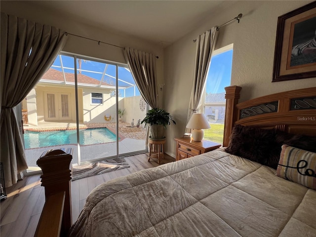 bedroom featuring access to exterior and hardwood / wood-style flooring