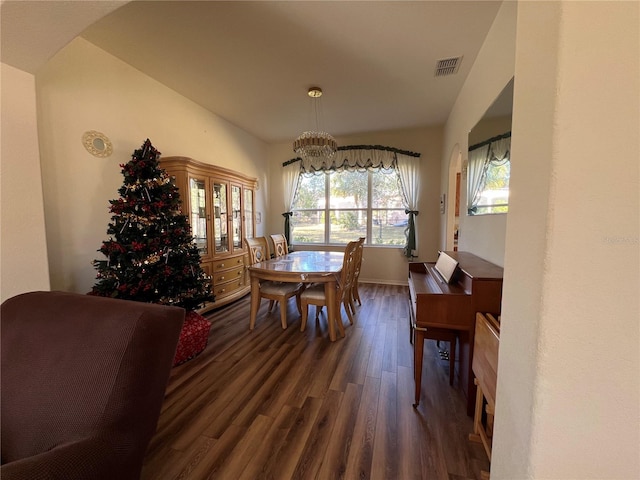 dining area with dark hardwood / wood-style floors and a notable chandelier