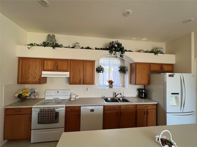 kitchen with white appliances, sink, light tile patterned floors, and tasteful backsplash