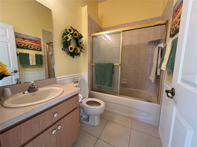 full bathroom featuring tile patterned floors, vanity, toilet, and combined bath / shower with glass door