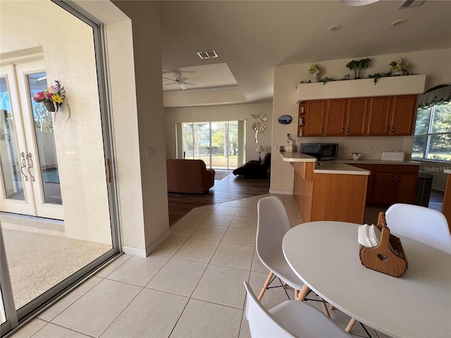 kitchen featuring ceiling fan, kitchen peninsula, and light hardwood / wood-style flooring