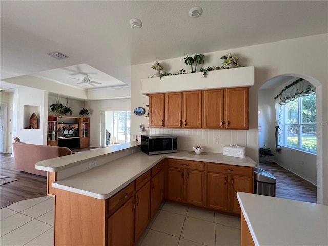 kitchen with kitchen peninsula, plenty of natural light, and light hardwood / wood-style floors