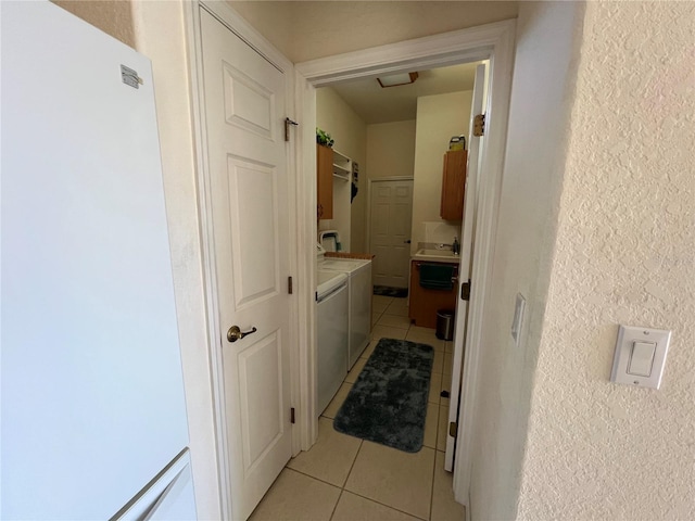 hallway featuring washer and dryer and light tile patterned floors