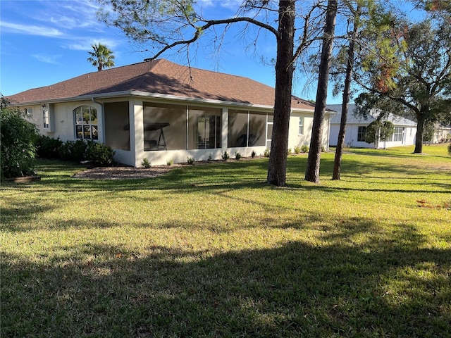 rear view of house with a sunroom and a yard