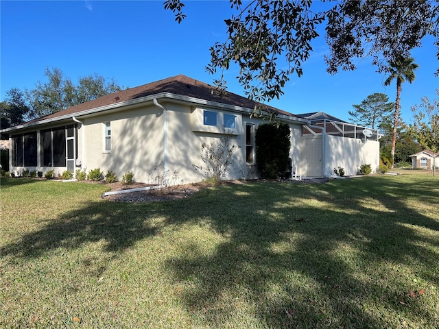 view of side of property featuring a lawn and a sunroom