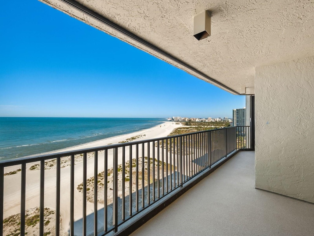 balcony featuring a water view and a view of the beach