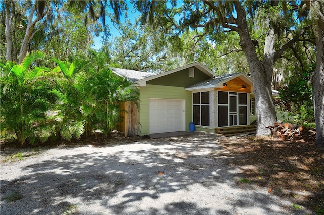 view of home's exterior with a sunroom and a garage