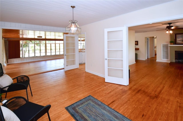 unfurnished room with ceiling fan, french doors, wood-type flooring, and built in features