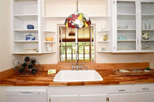 kitchen featuring decorative light fixtures, white dishwasher, white cabinetry, and butcher block counters