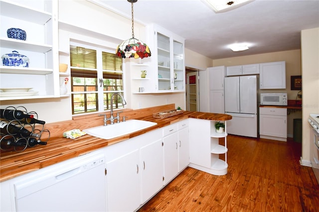 kitchen featuring sink, hanging light fixtures, dark hardwood / wood-style flooring, butcher block countertops, and white appliances