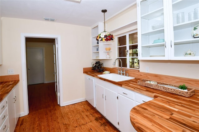 kitchen featuring wooden counters, sink, white cabinets, hardwood / wood-style floors, and hanging light fixtures