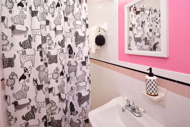 bathroom featuring sink, tile walls, and a shower with shower curtain