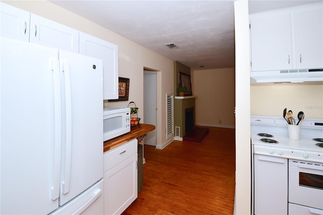 kitchen featuring white cabinets, white appliances, and hardwood / wood-style flooring