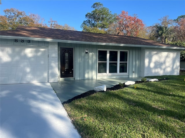 single story home featuring a garage and a front lawn