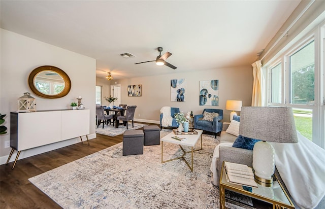 living room with ceiling fan and dark hardwood / wood-style flooring