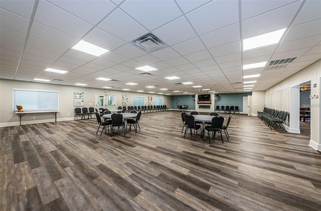 dining area with a paneled ceiling and wood-type flooring