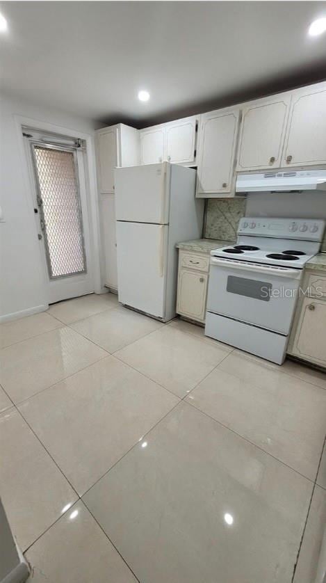 kitchen with decorative backsplash, white cabinetry, white appliances, and light tile patterned floors